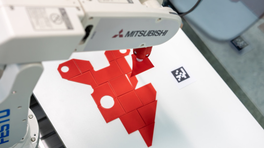 Roboter legt Objekt an definierter Position ab.