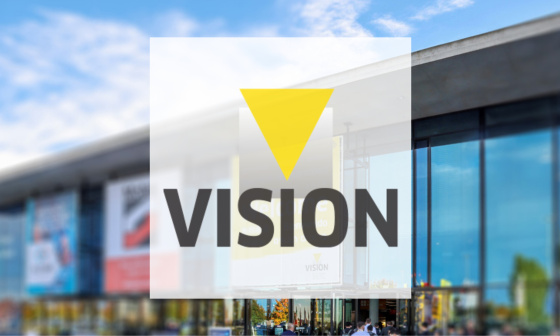 VISION Logo im Vordergrund und Messehalle im Hintergrund
