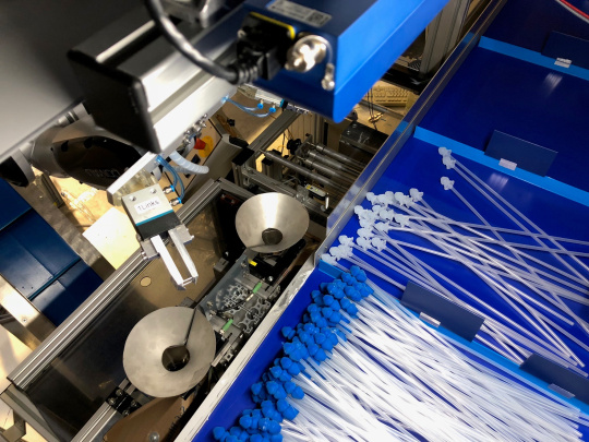 Ein Roboter sortiert mithilfe einer Ensenso 3D Kamera Katheder mit blauen und weißen Aufsätzen.