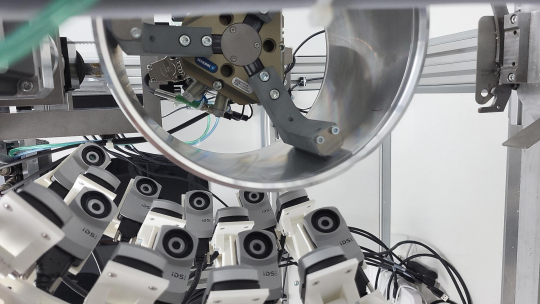 Mehr als ein Dutzend IDS uEye XC-Kameras erfassen die äußere Oberfläche eines runden Aluminium-Bauteil.