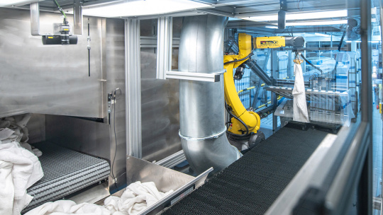 Roboter mit 3D-Kamerasystem faltet Handtücher in Großwäscherei