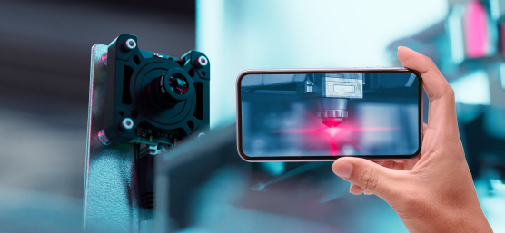 Smartphone zeigt Automatisierungsprozess, daneben eine uEye Live Monitoring-Kamera