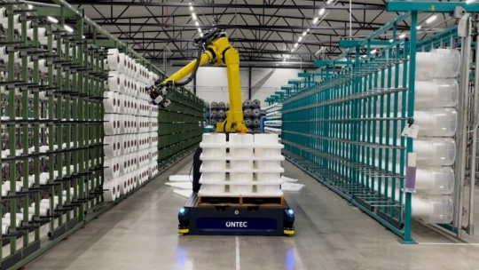 Pick-and-Place von Roboter in einer Logistikhalle mit Papierrollen