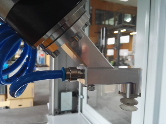 Roboterarm in einer Roboterzelle mit blauen Kabel