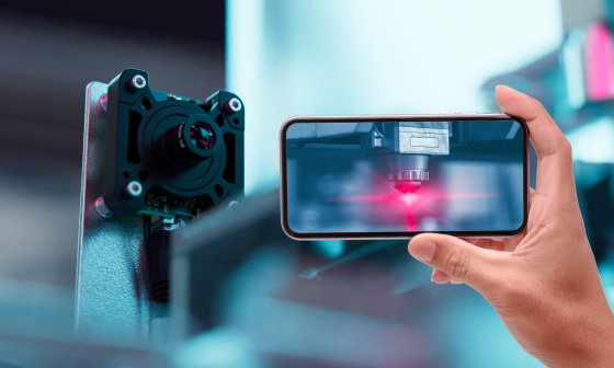 Smartphone zeigt Automatisierungsprozess, daneben eine uEye Live Monitoring-Kamera