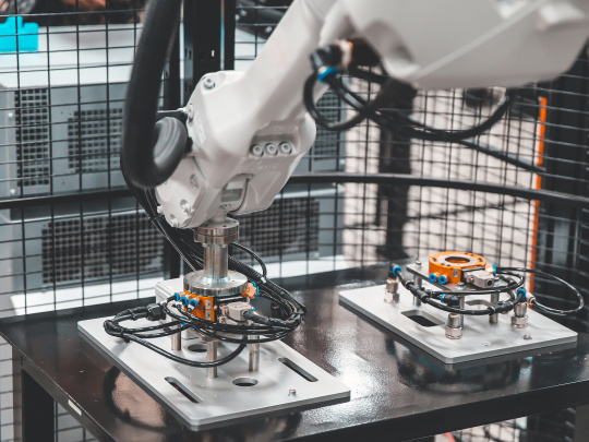 Weißer Roboterarm in einer Maschine mit einer uEye+ XLS 2D Kamera von IDS.