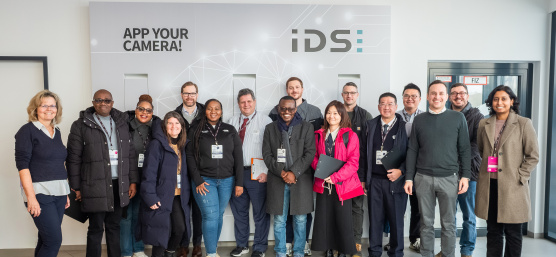 14‑köpfige MIT REAP‑Delegation beim Besuch bei IDS vor einer Firmenwand