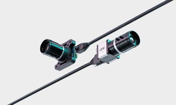 Diagonal angeordnet liegen zwei IDS uEye Live Monitoring-Kameras mit Kabel.