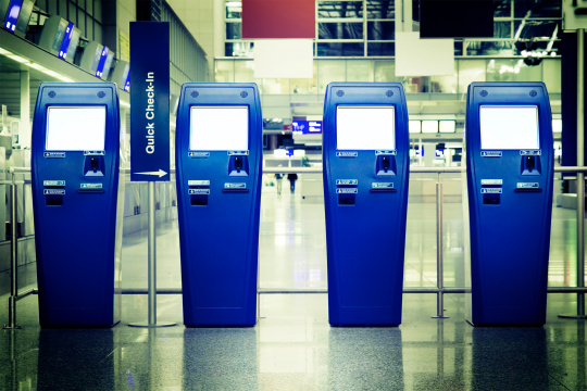 Vier Quick Check-In Terminals in einer Flughafenhalle