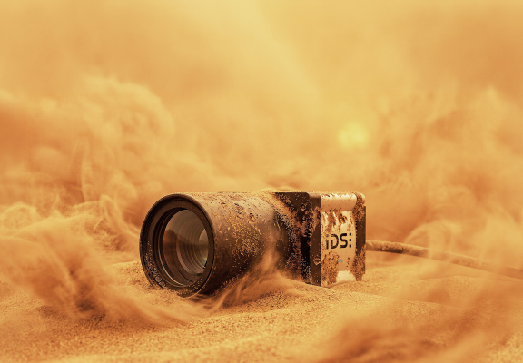 IDS-Industriekamera im Sand mit Staubwolken