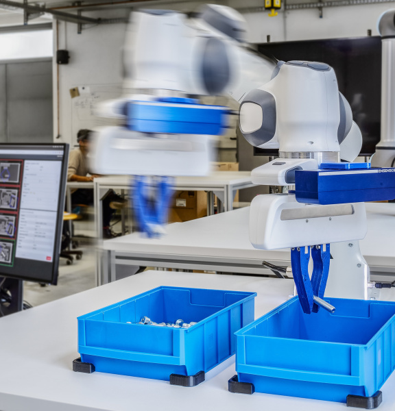 Ein sich schnell bewegender Roboterarm mit Ensenso Kameras sortiert Schrauben