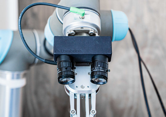 Zwei IDS Kameras an Roboterarm liefern Bilder für schnelle und exakte Bin-Picking Anwendungen