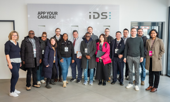 14‑köpfige MIT REAP‑Delegation beim Besuch bei IDS vor einer Firmenwand