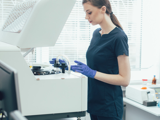 Eine Frau im Labor nimmt ein Diagnosegerät mithilfe einer IDS uEye+ XLE Kamera in Betrieb.