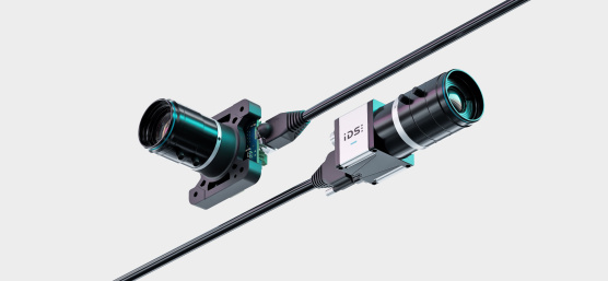 Diagonal angeordnet liegen zwei IDS uEye Live Monitoring-Kameras mit Kabel.