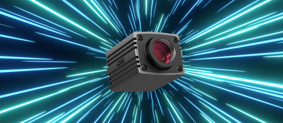 IDS Industriekamera uEye Warp10 vor blauen und grünen Strahlen-Effekten