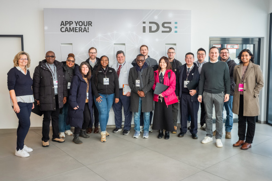 Besuchergruppe des MIT REAP‑Programms beim Aufenthalt bei IDS vor einer Markenwand