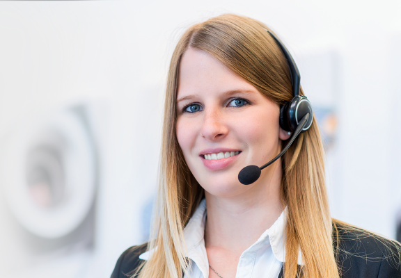 Eine IDS Mitarbeiterin mit einem Headset zum Telefonieren.