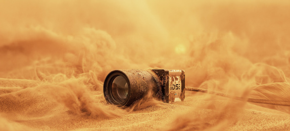 IDS-Industriekamera im Sand mit Staubwolken