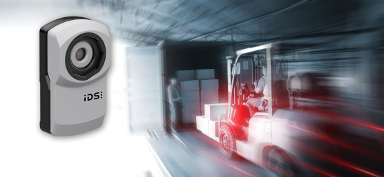 uEye XC Kamera schwebt neben dynamischer Szene mit Gabelstapler und LKW.