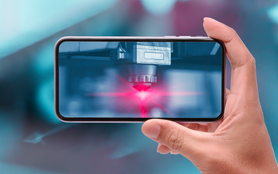 Hand hebt Handy horizontal, auf Handy leuchtet ein rotes Licht