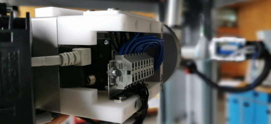 Setup bestehend aus einer GigE Vision Kamera von IDS inkl. Beleuchtung, montiert auf einem Roboterarm