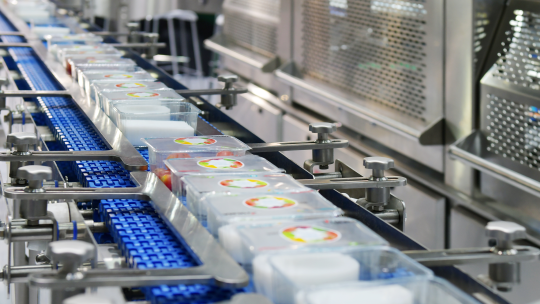 Verpackte Lebensmittelbehälter auf automatisierter Förderlinie