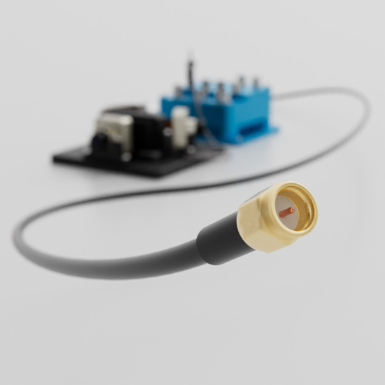 Goldfarbener Koaxialstecker mit Kabel vor einer unscharfen Platine